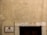 A weathered exterior wall with a rough texture, featuring a rectangular sign on the left side displaying 'CLUBE DE OFICIAIS DA MARINHA MERCANTE'. Above a dark wooden door is the number '21' inscribed on a stone lintel, and a single cable runs vertically down the right side.