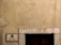A weathered exterior wall with a rough texture, featuring a rectangular sign on the left side displaying 'CLUBE DE OFICIAIS DA MARINHA MERCANTE'. Above a dark wooden door is the number '21' inscribed on a stone lintel, and a single cable runs vertically down the right side.