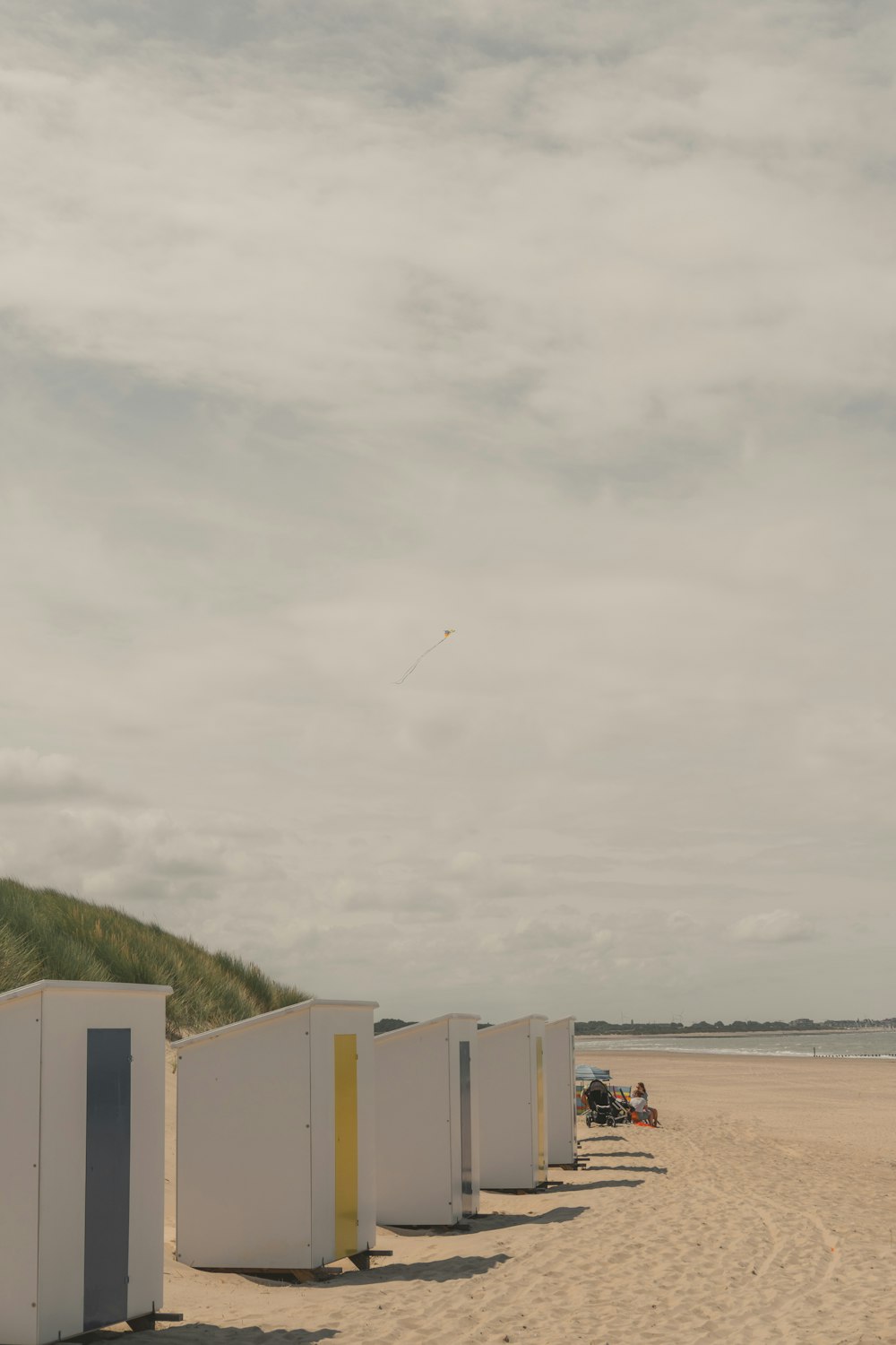 a row of portable toilets sitting on top of a sandy beach