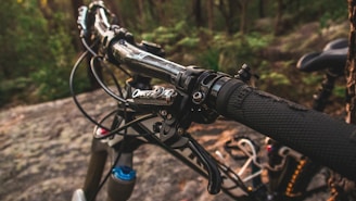 Close-up of our cycling gloves gripping a vibrant mountain bike handlebar outdoors.