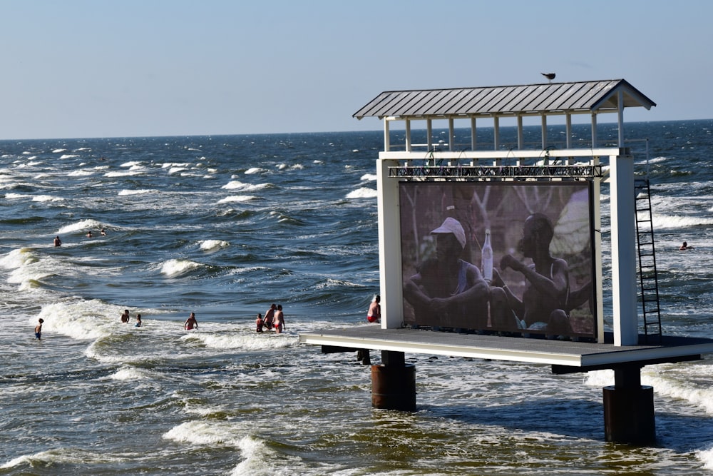 a billboard on a pier in the middle of the ocean