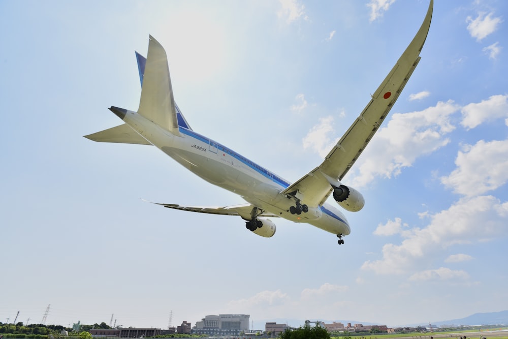 white and blue airplane under white sky at daytime