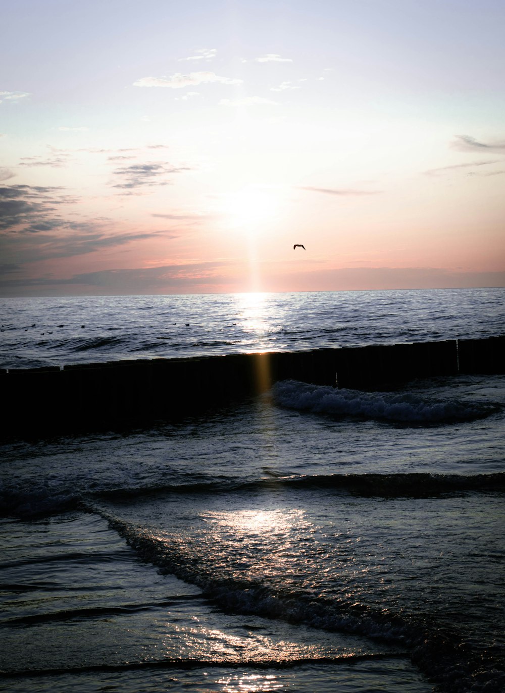 water wave under white sky at golden hour