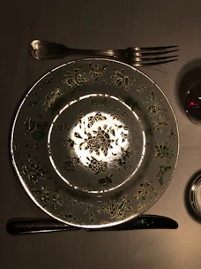 Handcrafted plates with playful patterns and warm tones set on a linen tablecloth with natural light.