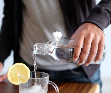 man pouring water in glass