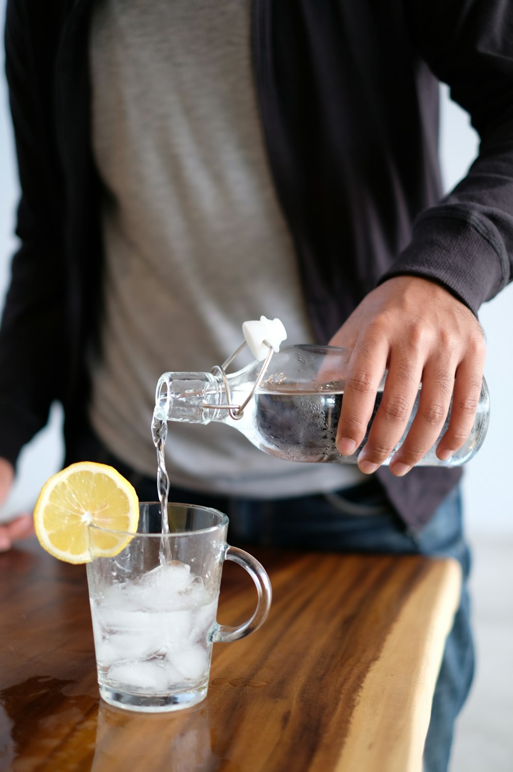 Mann gießt Wasser in Glas