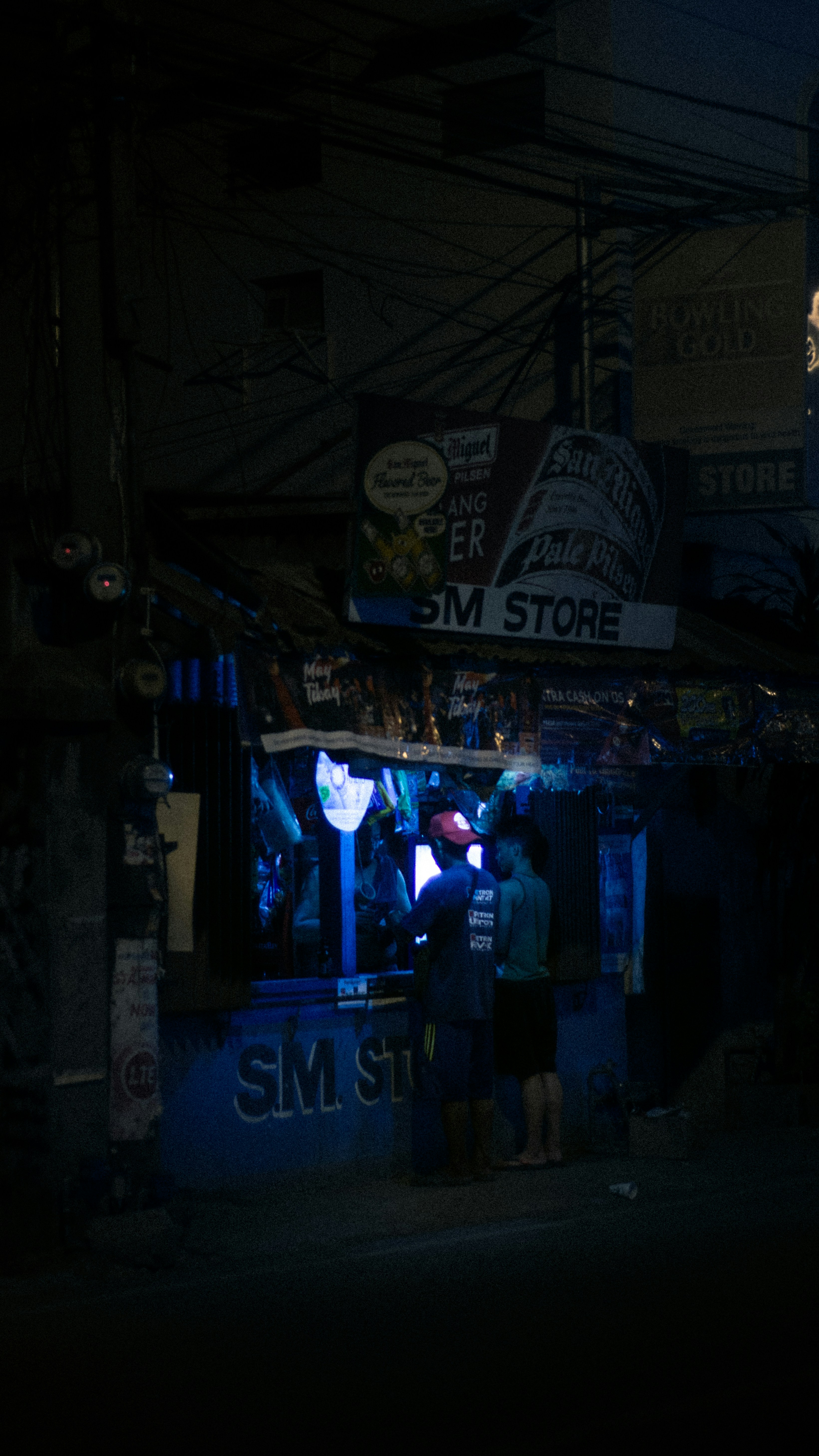 a group of people standing outside of a store at night