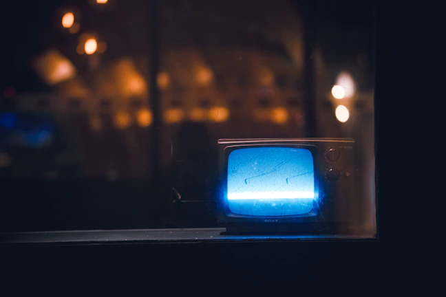 A dimly lit background with a vintage television set playing a classic show from decades ago.