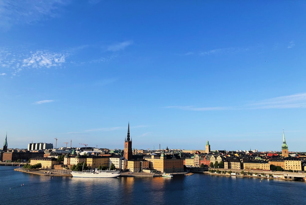 city buildings near body of water under blue sky