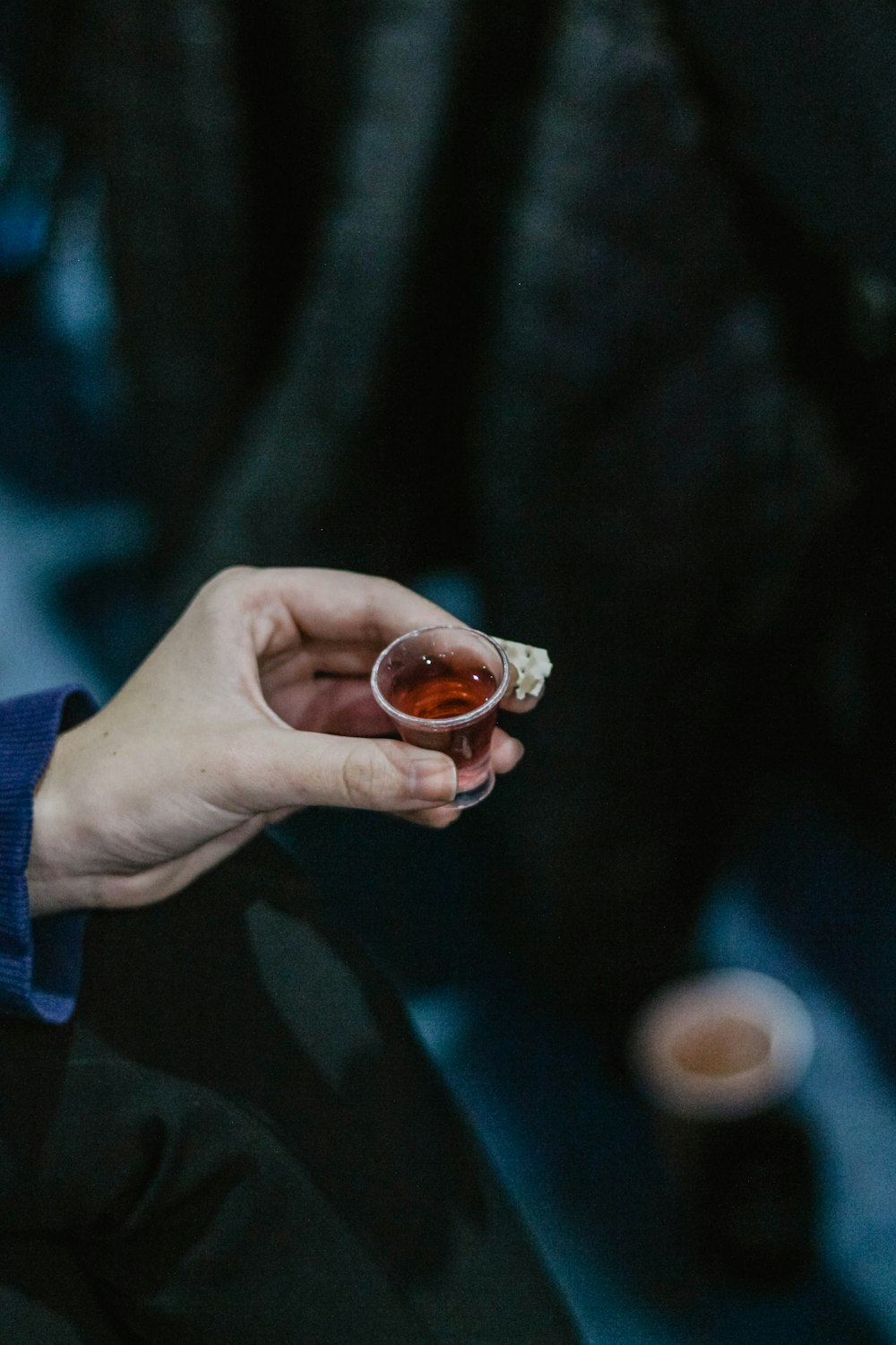 person holding shot glass with liquor