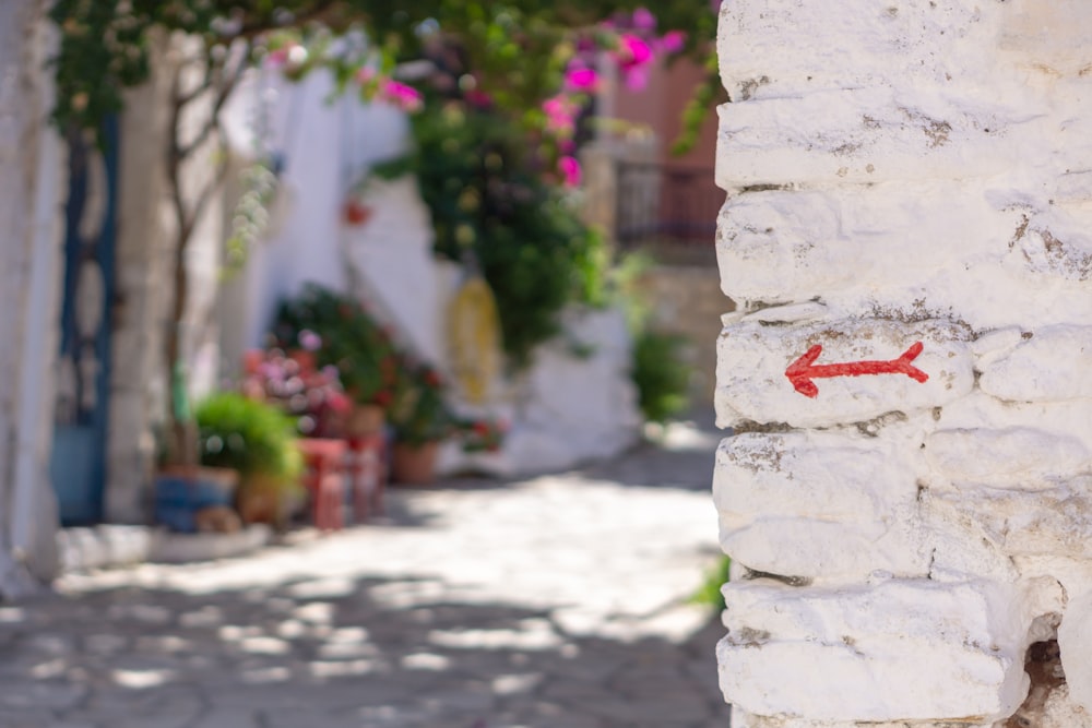 a red arrow painted on a white brick wall