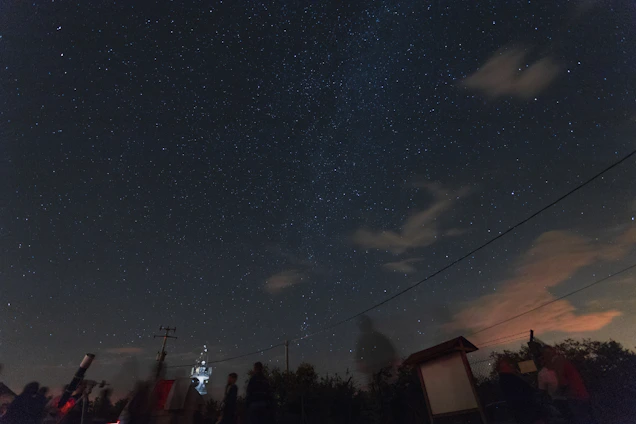 Dr. Nandkishor Meshram engaging with students during a hands-on astrophysics workshop under a starry night sky.