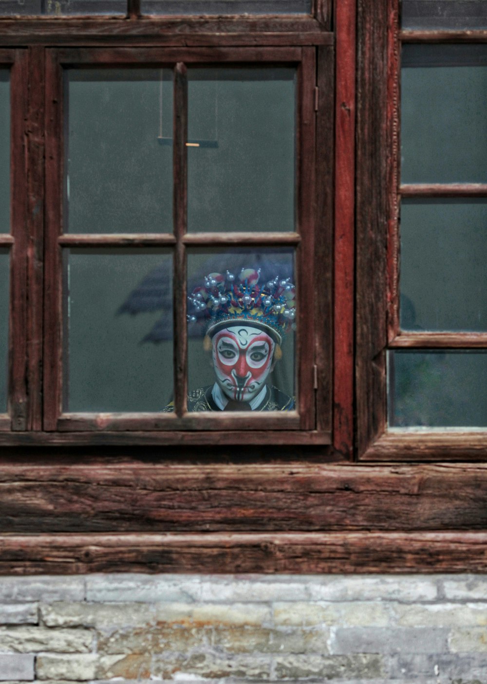 man wearing mask behind glass window