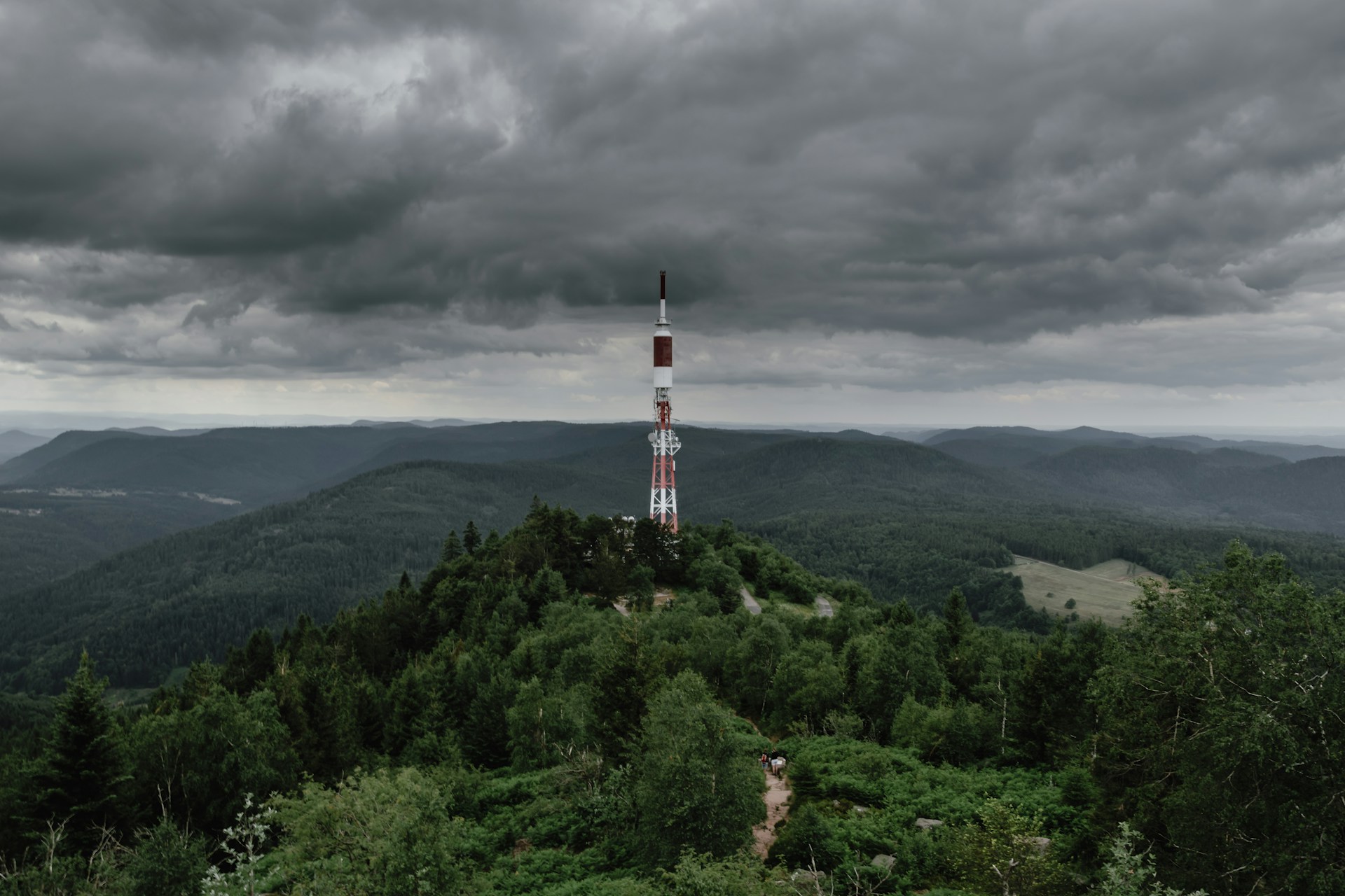 white and red tower on mountain under white and gray skies