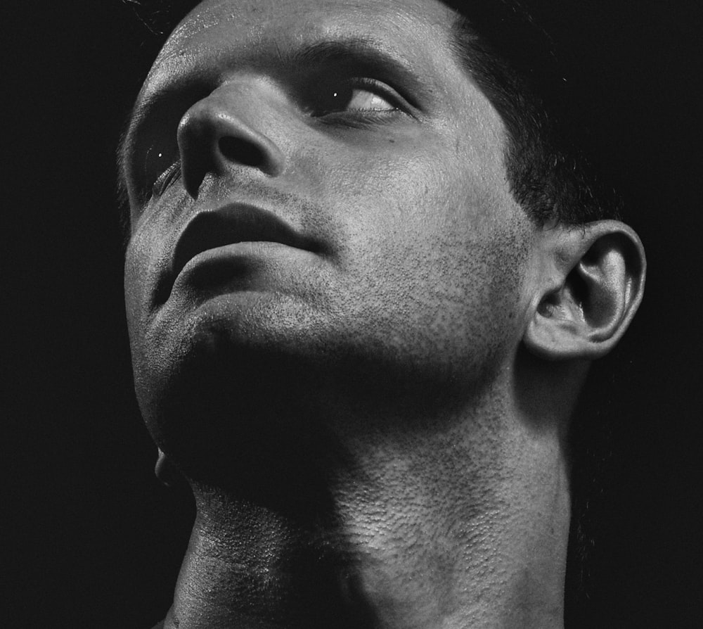 a black and white photo of a man looking up