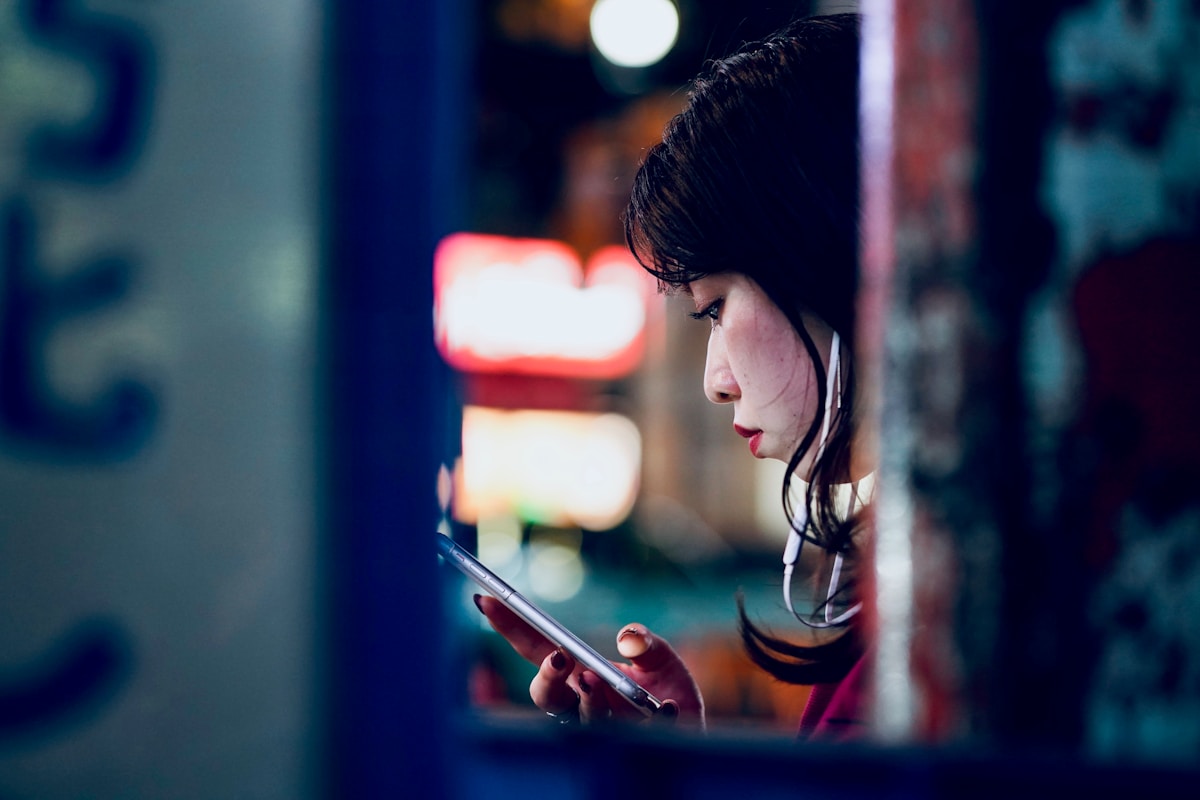 Woman using smartphone at Shibuya Crossing in Tokyo, Japan
