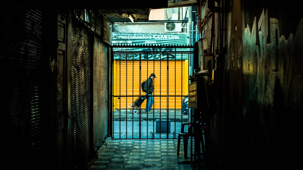 man pulling luggage while walking near pathway beside building