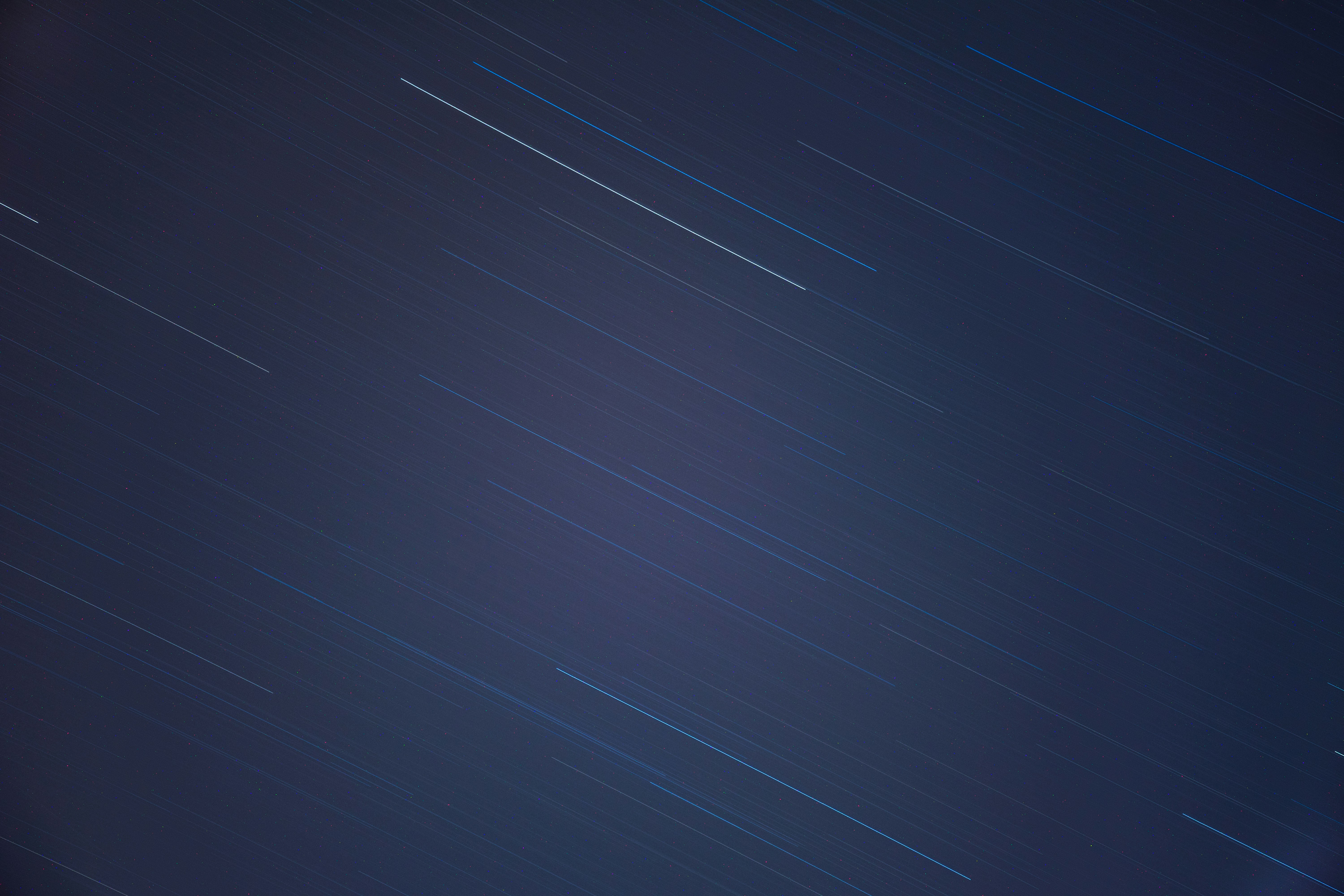 a night sky with stars and a plane in the sky