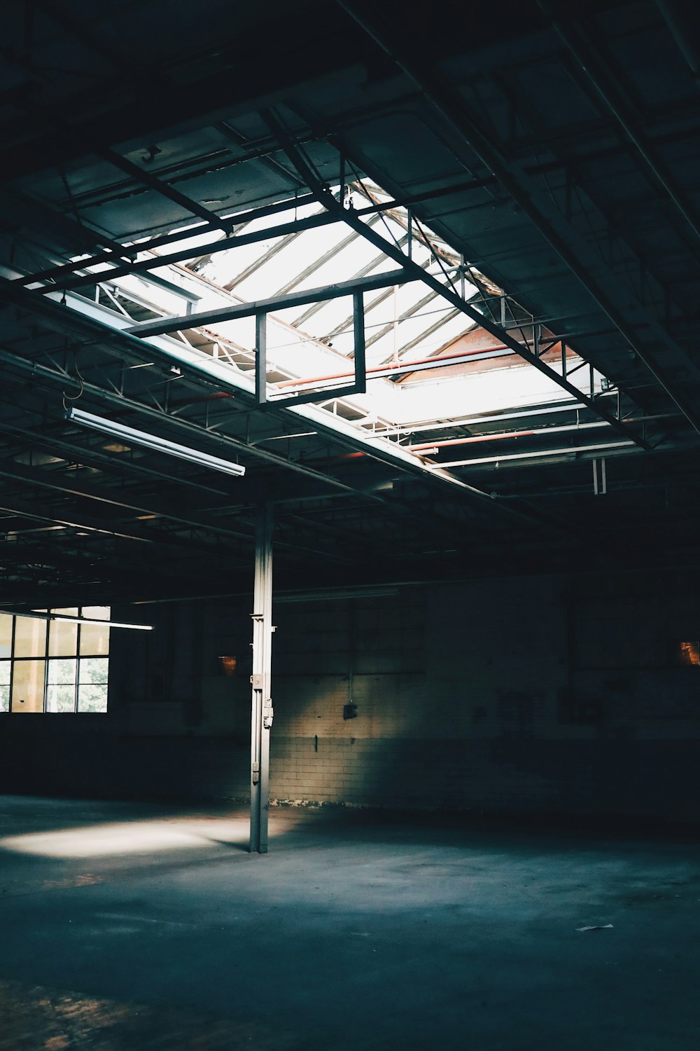 an empty warehouse with a skylight in the middle of it
