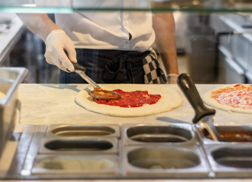 A chef preparing pizzas in the kitchen