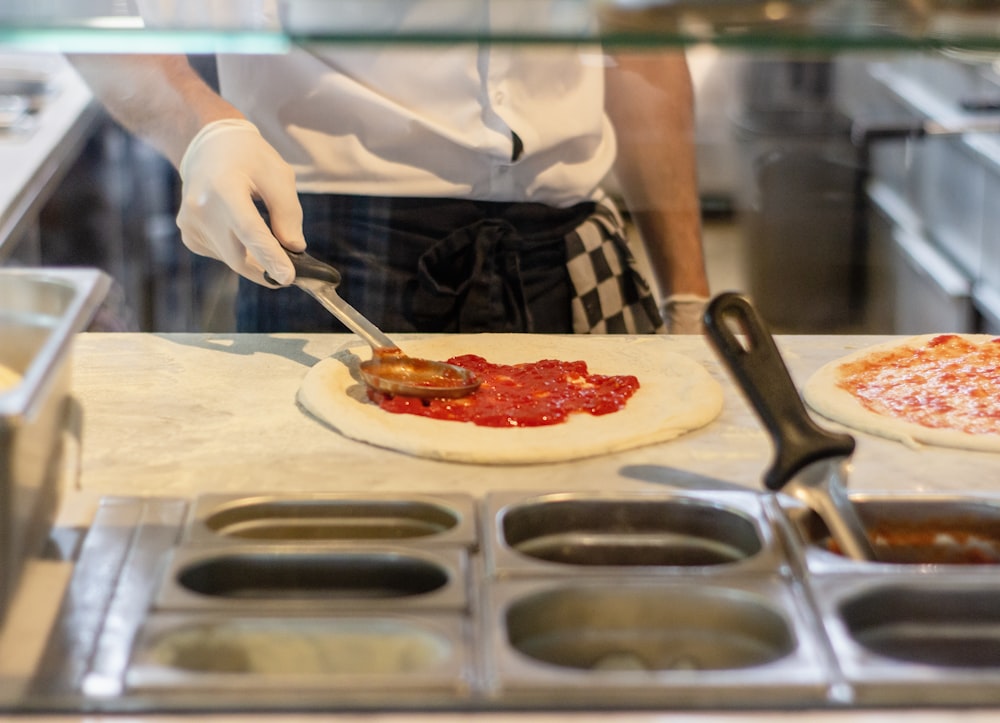 a chef is preparing pizzas in a kitchen