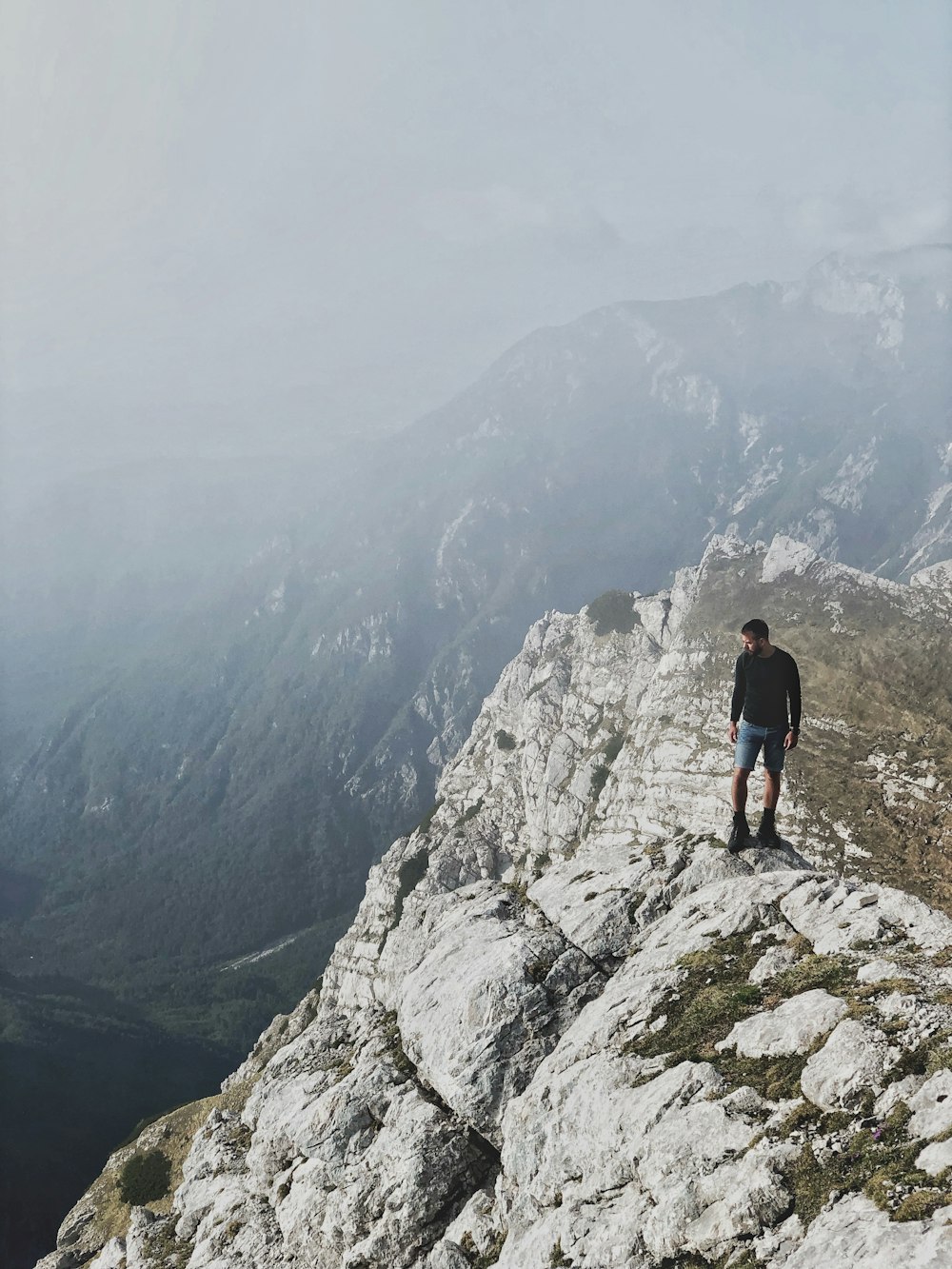 uomo in piedi su una scogliera di montagna