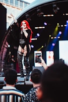 A singer passionately performing a Sicilian ballad, framed by the festival’s signature deep red stage curtains.