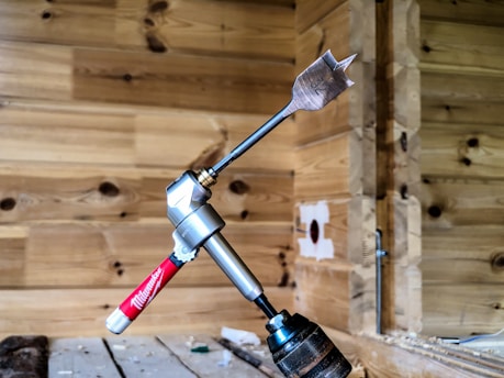 Worker drilling into concrete wall with professional equipment.