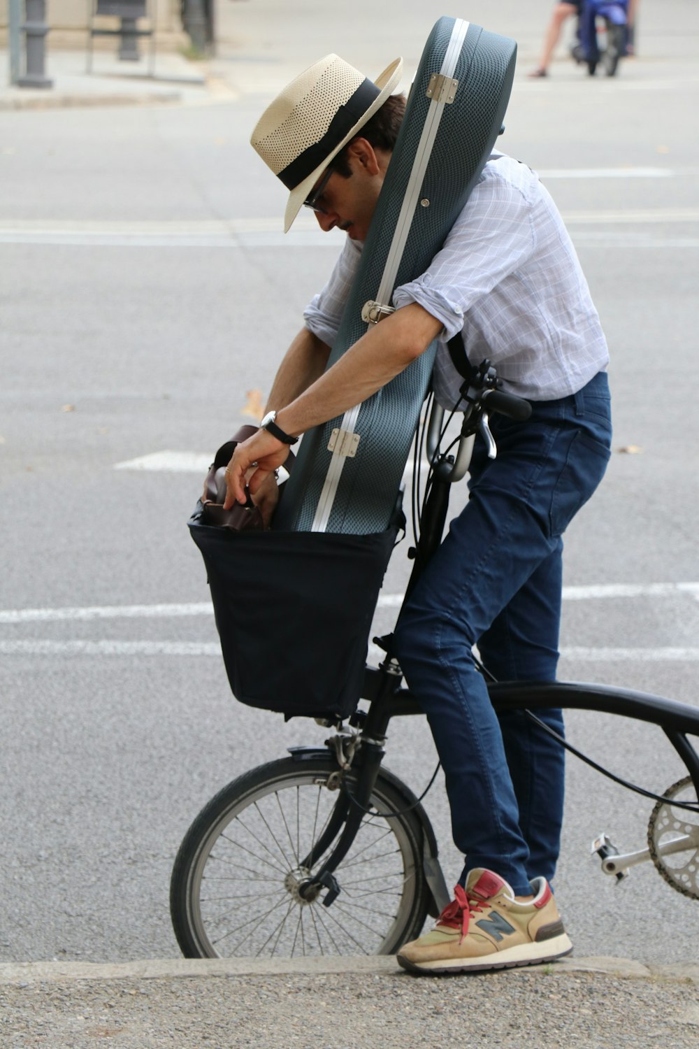 man riding bike with guitar case