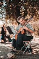 A solo musician playing a classical guitar outdoors.