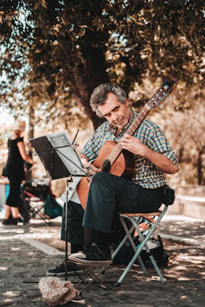 A solo musician playing a classical guitar outdoors.