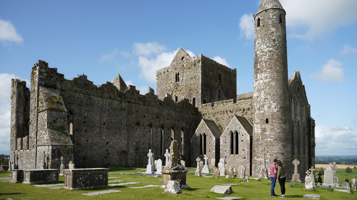 people standing near brown castle under blue sky and white clouds