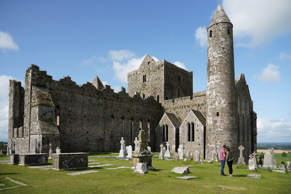 people standing near brown castle under blue sky and white clouds