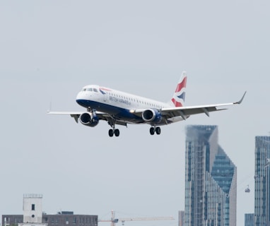 white, red, and blue airplane above buildings