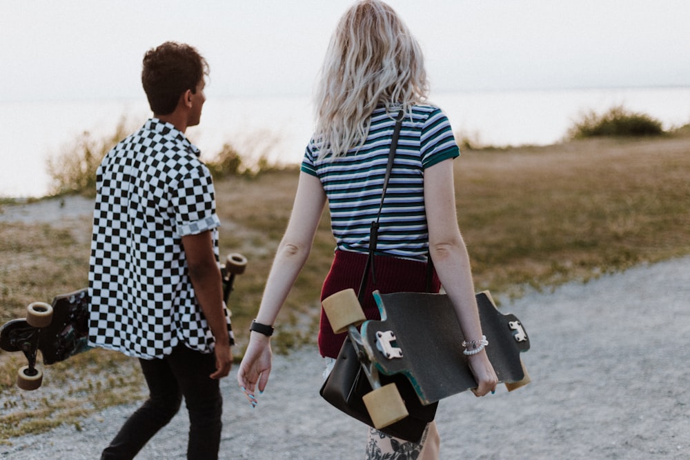 man and woman in white-and-black tops walking on pathway during daytime