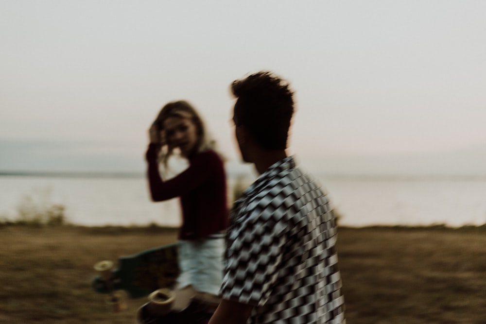 man and woman walking on seashore during daytime