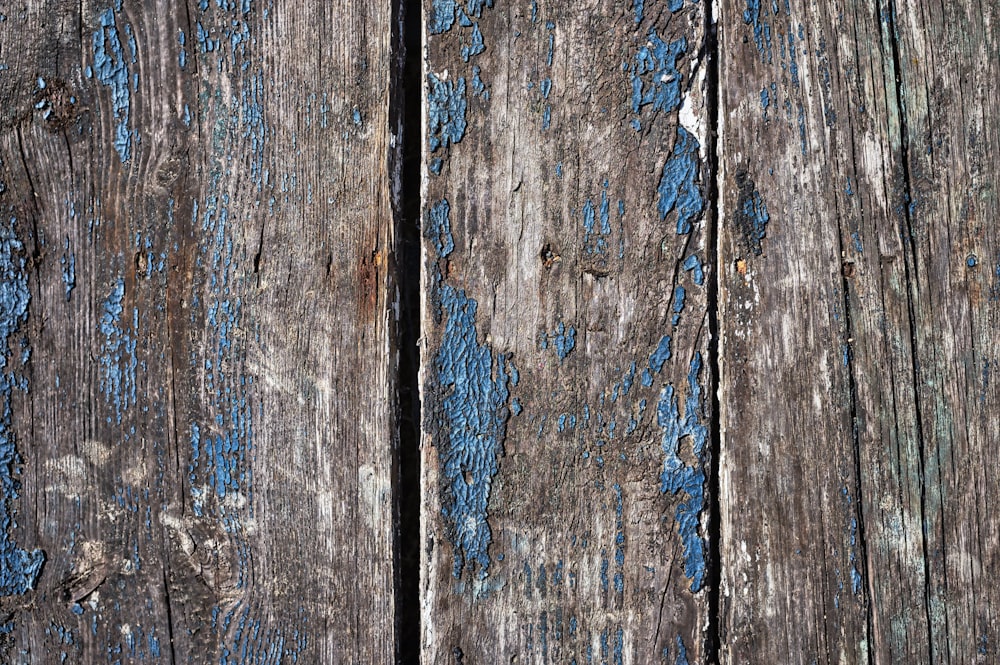 a close up of a wooden surface with blue paint