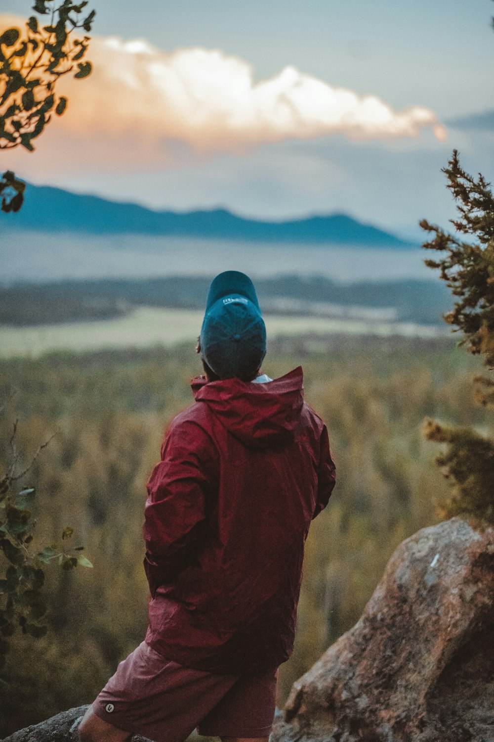 man standing on rock while looking up in the sky