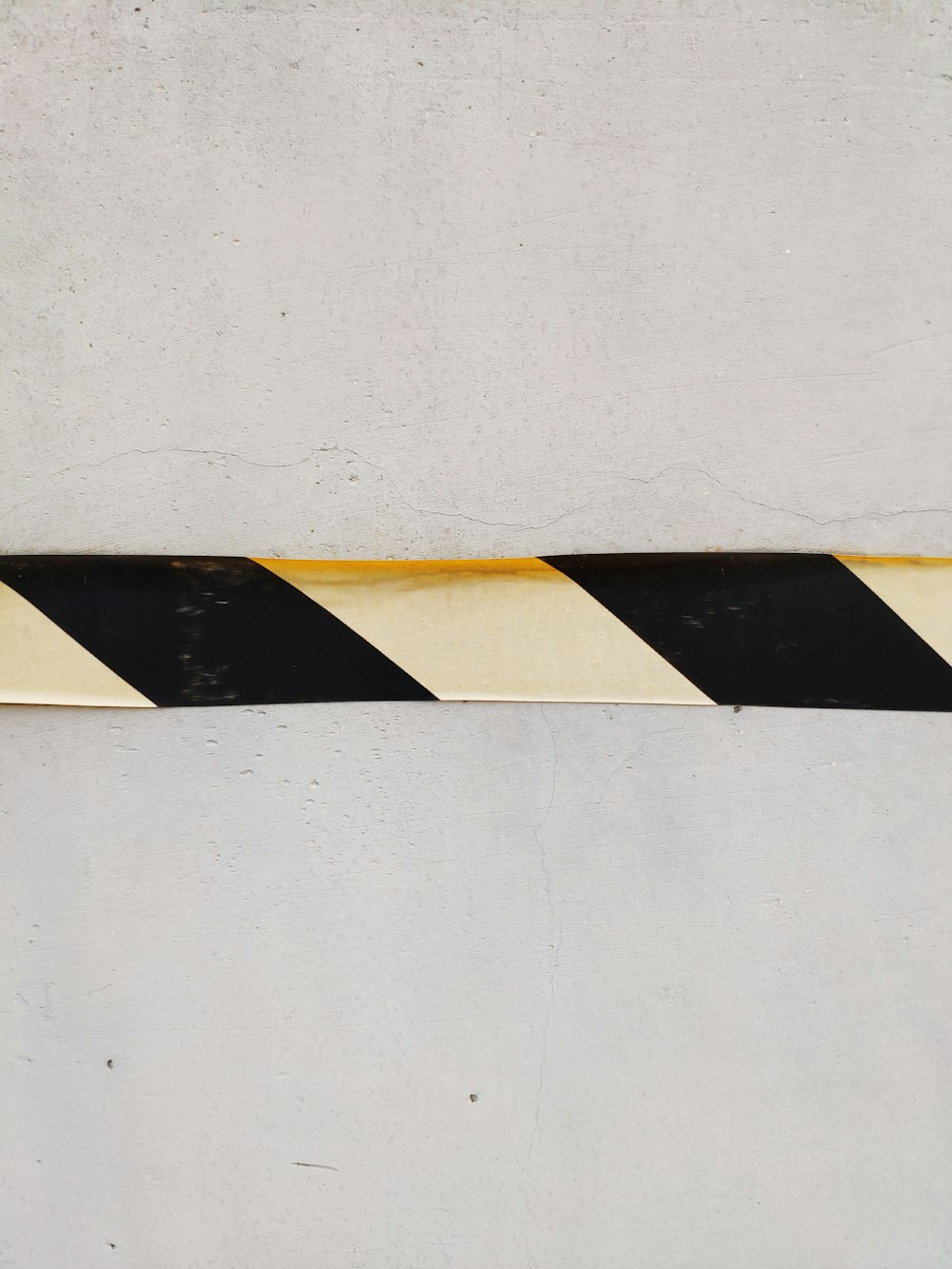 a black and white striped sign on a wall