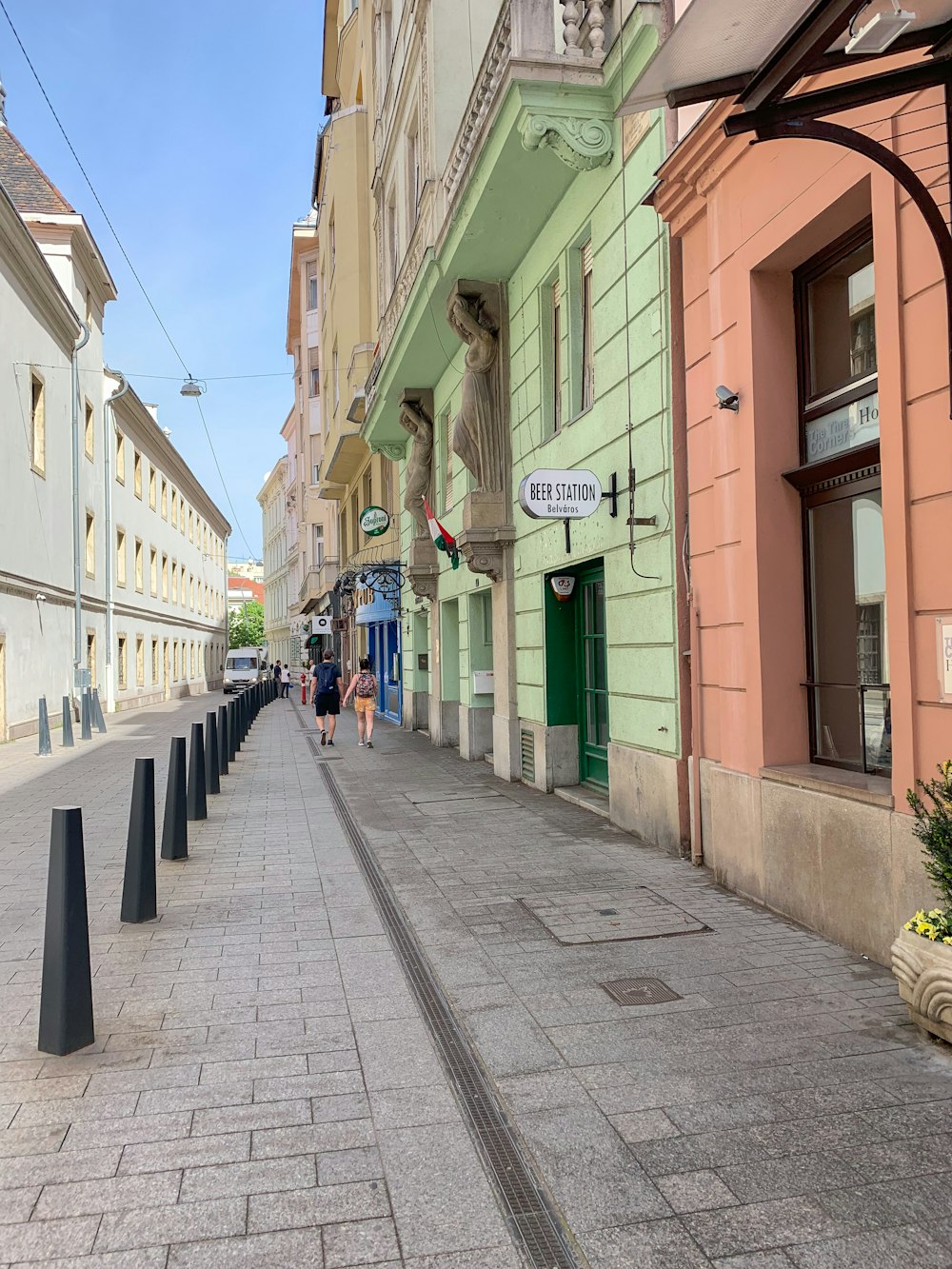 two person walking between buildings