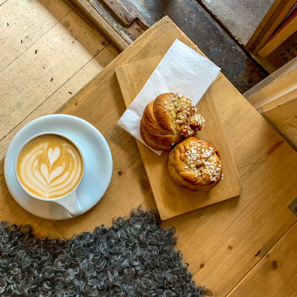 A cinnamon bun and coffee laid out for a Swedish fika break