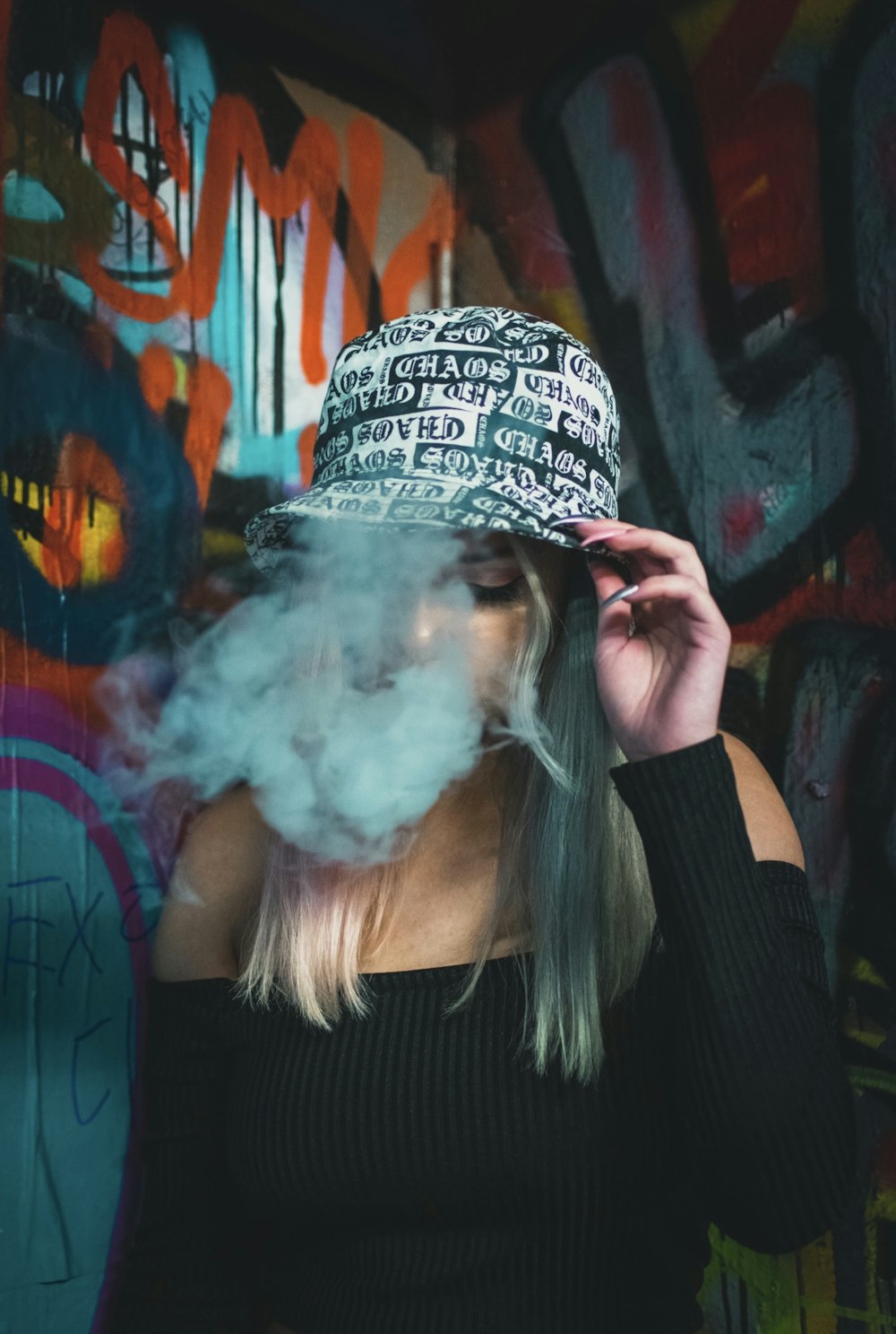woman wearing black and white bucket hat smoking