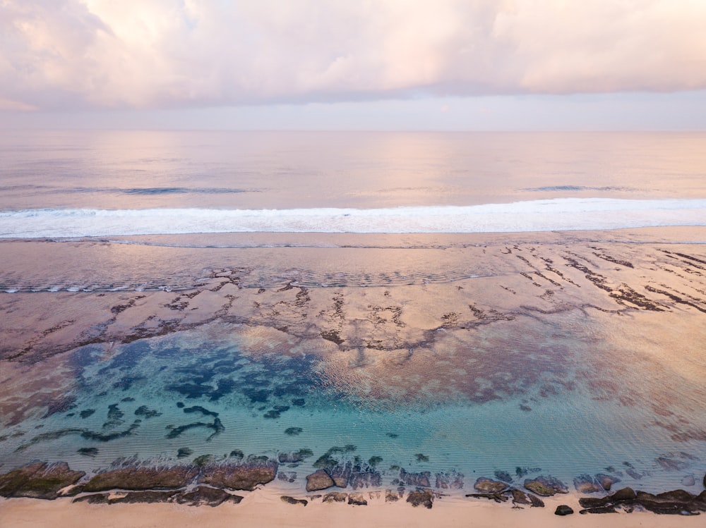 an aerial view of a beach with a body of water