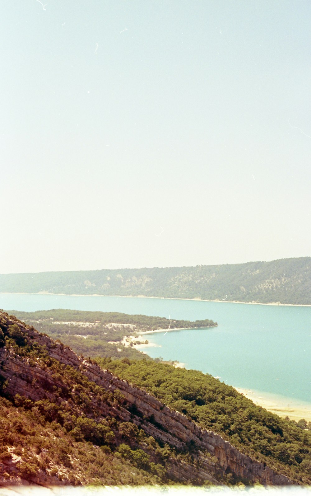 a man standing on top of a mountain next to a body of water