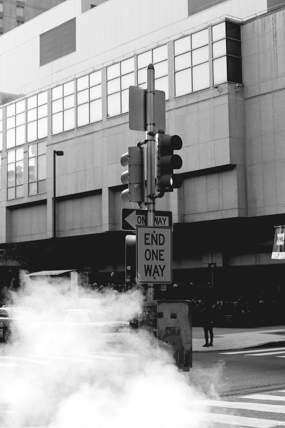 a black and white photo of a street sign with smoke coming out of it