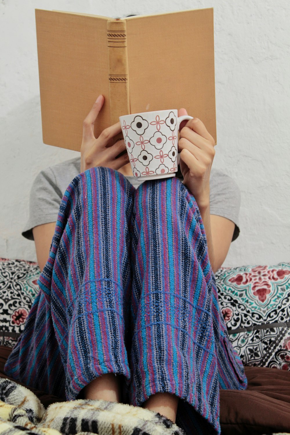 person covering face with book