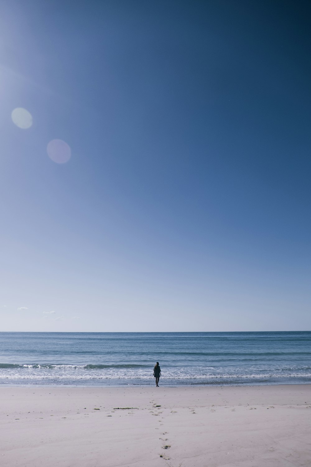 a person standing on a beach next to the ocean