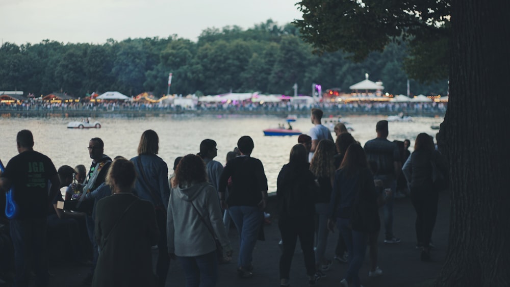 a group of people standing next to a body of water