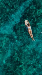 woman wearing white top and panty on body of water