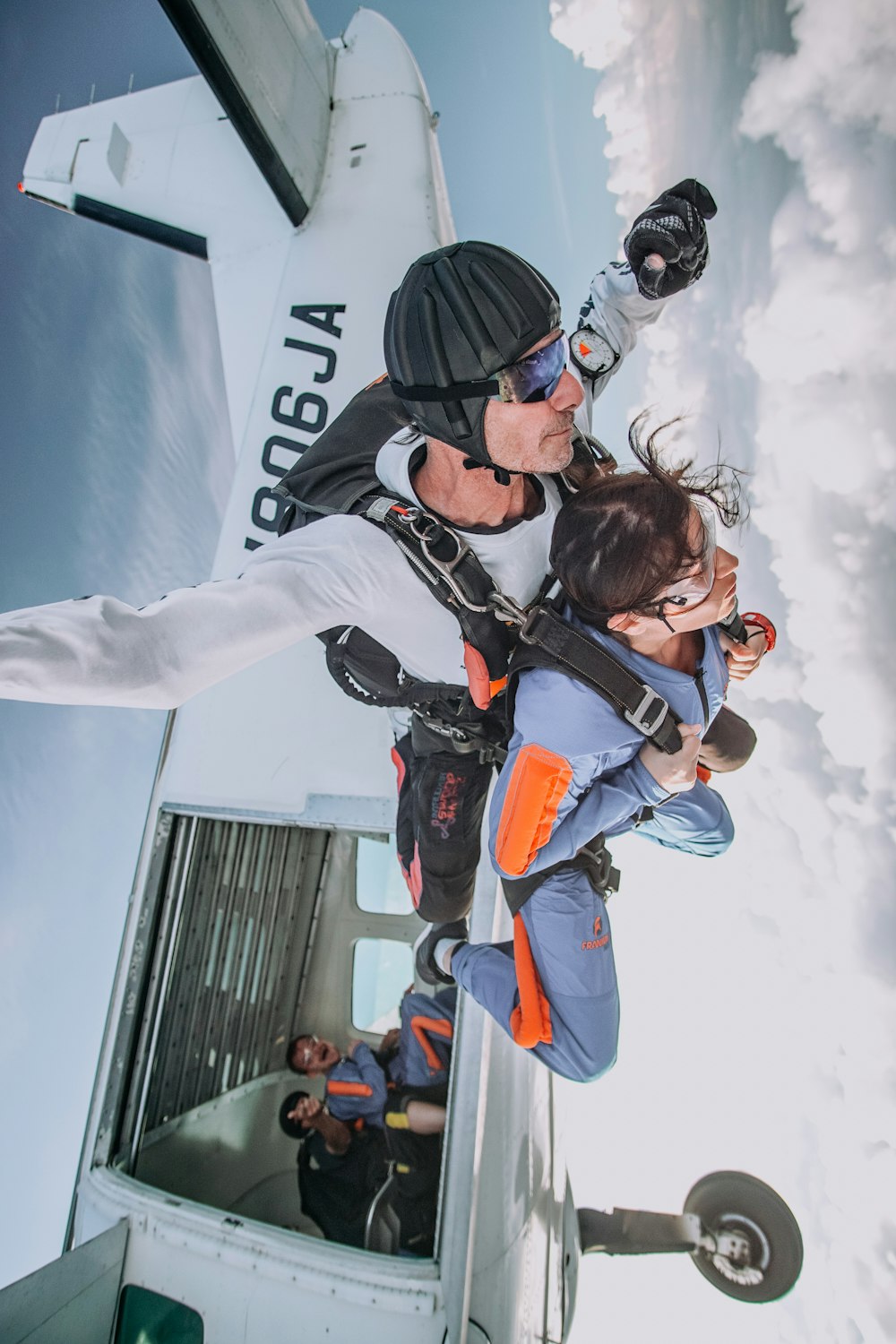 photographie d’homme et de femme faisant du parachutisme pendant la journée